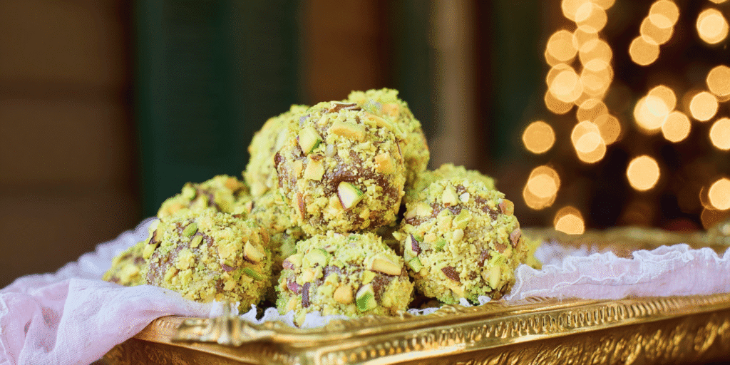 pistachio truffles coated in crushed nuts on gold tray